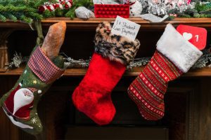 3 Christmas stockings hanging on a fireplace mantel