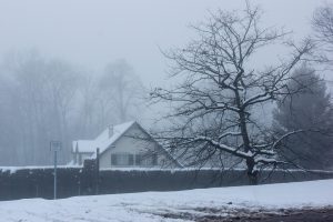 Photo of house covered in snow during winter