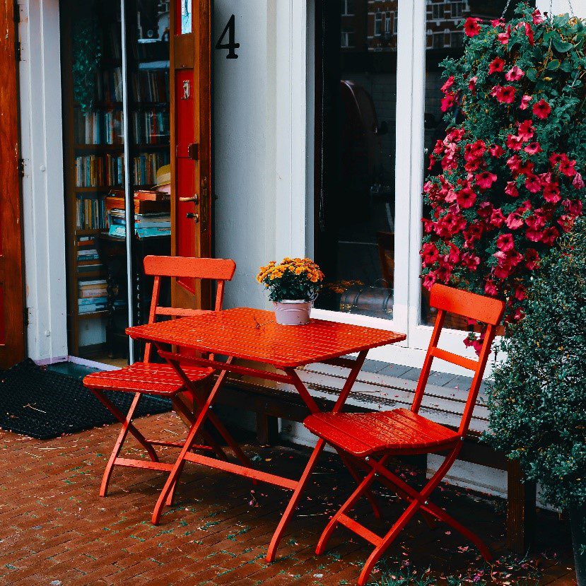 bright red patio table and chairs outside a bookstore.