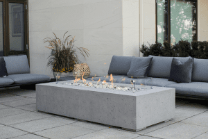 Outdoor fire pit on a patio surrounded by couches in a