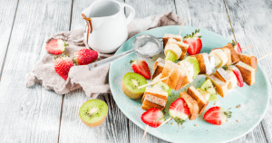 Breakfast plate holding cut strawberries and kiwis