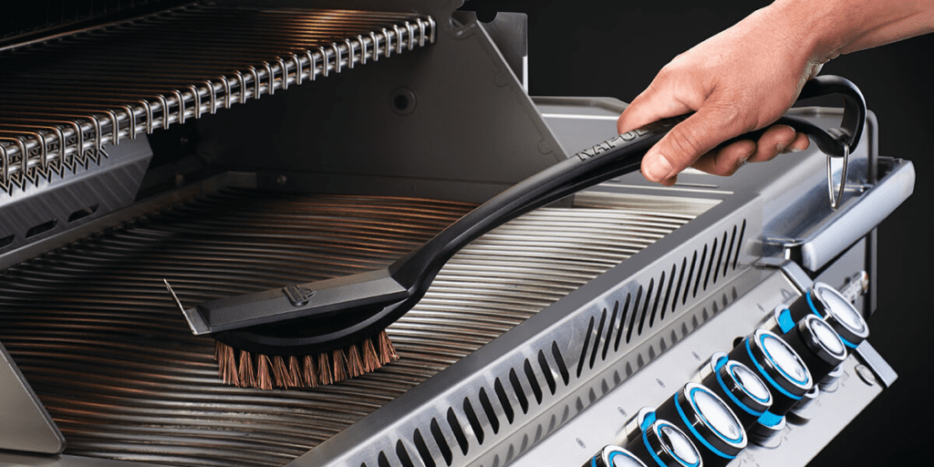 A brush cleaning a gas grill.