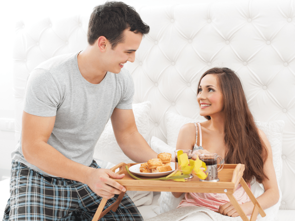 Couple in bed having breakfast for Valentine's Day.