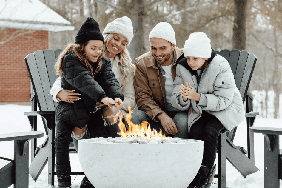 A Family sits around a firepit in their backyard