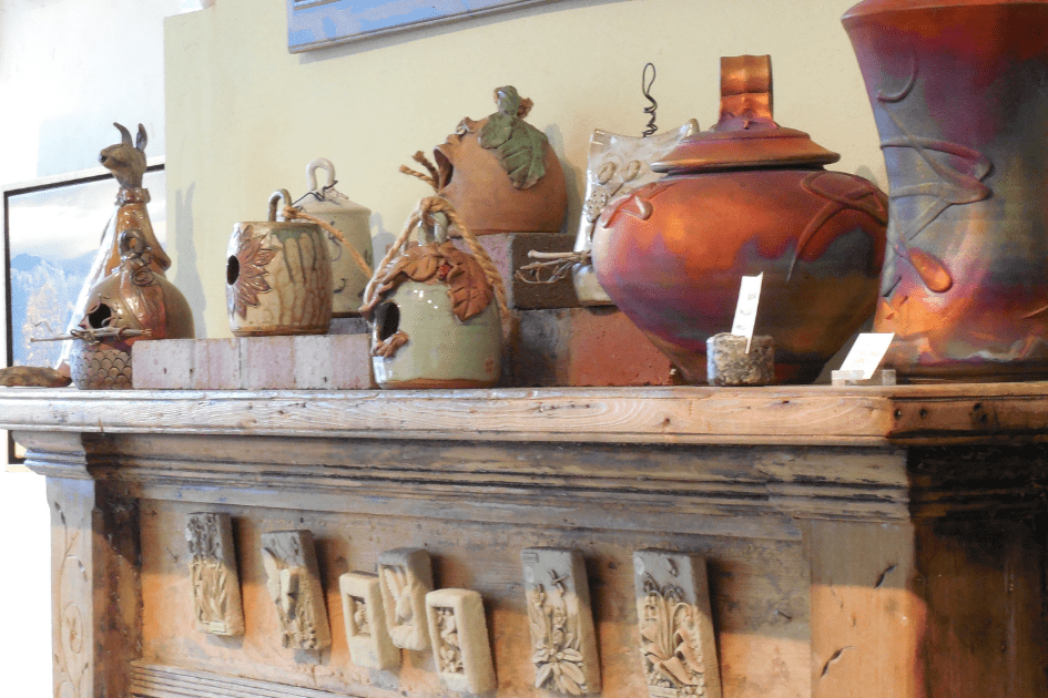 Different colours of vases on a fireplace 