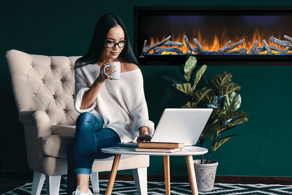 A woman sits in front of her electric fireplace