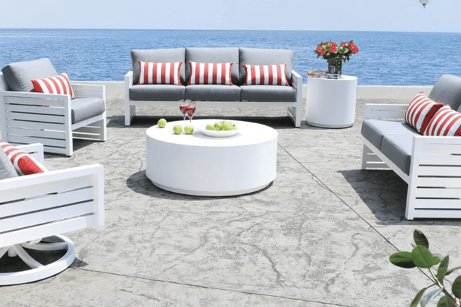 A Cabana Coast aluminum patio set in white with light grey cushions and red and white striped accent cushions