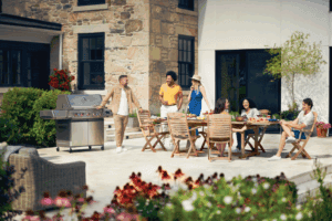 a group of friends gather around a patio setup for a BBQ